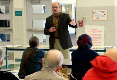 Answering questions at the community pizza party and meeting